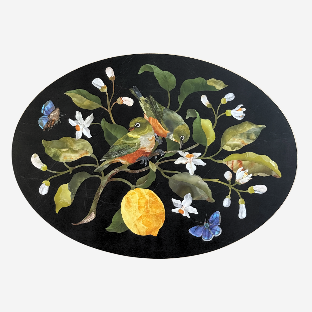 Decorative oval mat with birds, flowers, and a lemon on a black background