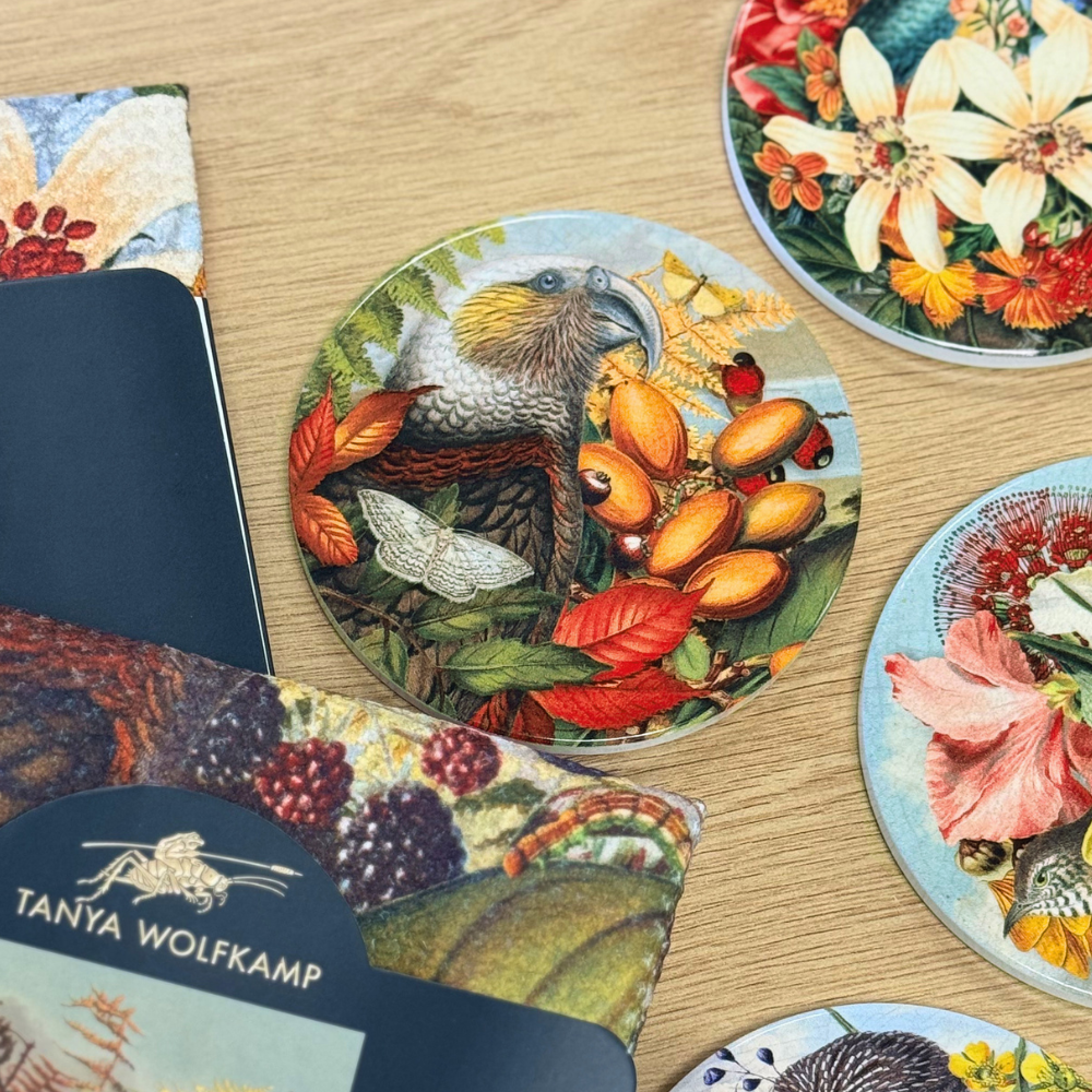 Colorful nature-themed coasters on a wooden surface with a Tanya Wolfkamp product in the foreground.