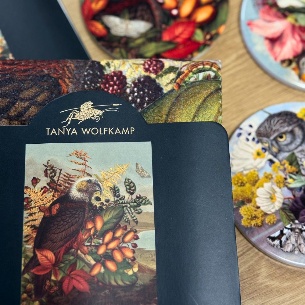 Card with nature-themed design and 'Tanya Wolfkamp' branding on a wooden surface.