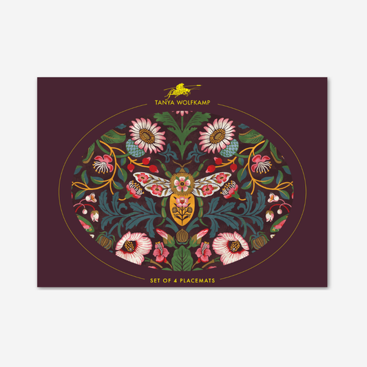 Decorative placemat with floral and butterfly design on a purple background, featuring the brand 'Tanya Wolfkamp'.