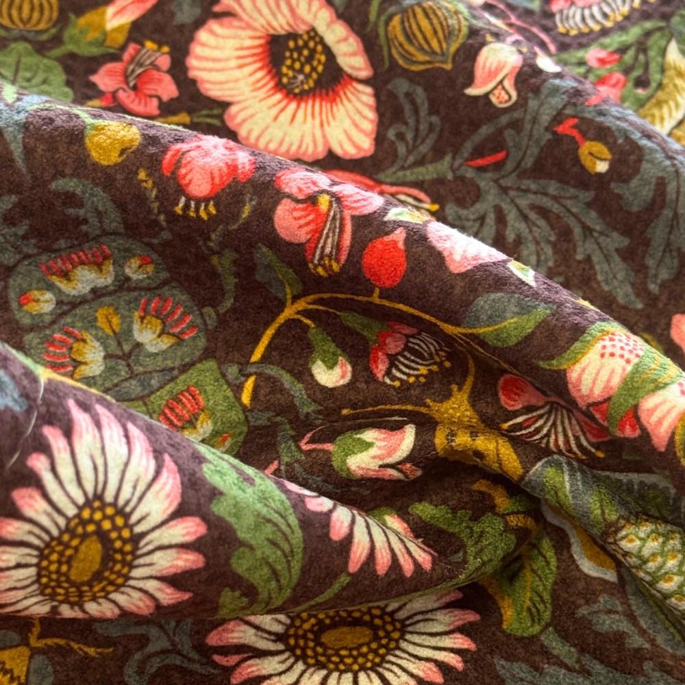 Close-up of floral fabric with pink, green, and yellow flowers on a dark background