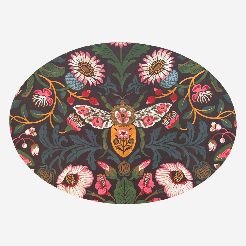 Round decorative mat with floral and insect design on a dark background