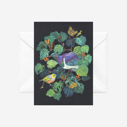 Greeting card with kereru and kawakawa on a black background, accompanied by a white envelope.