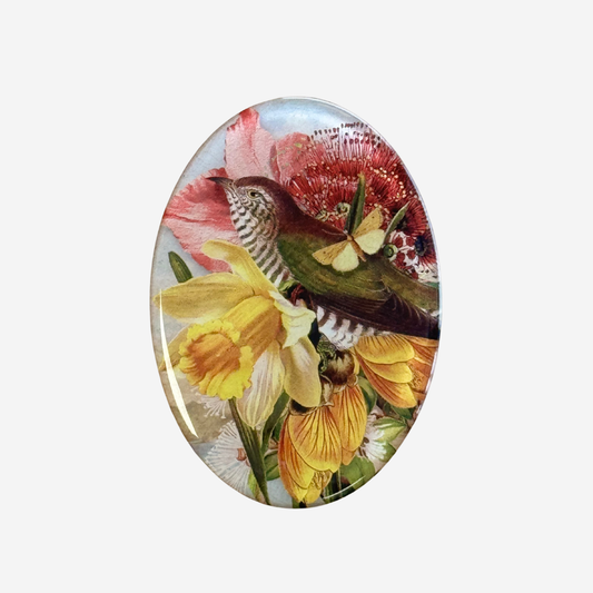 Oval fridge magnet with cuckoo and spring flowers  by Tanya Wolfkamp