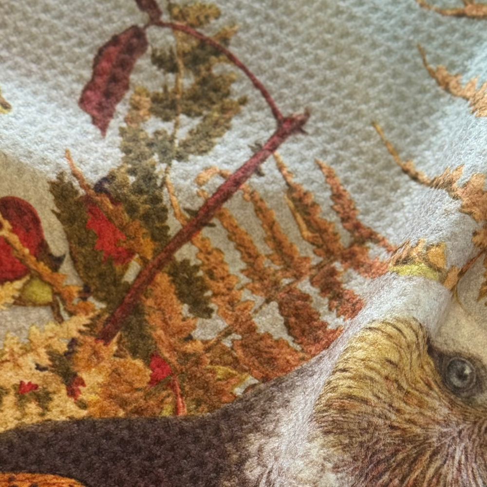 Close-up of a detailed rug with a squirrel and autumn leaves design.